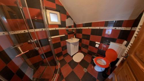 a small bathroom with a shower and a toilet at Simon House in Şimon