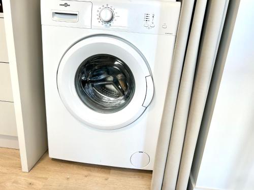 a white washing machine in a room with curtains at Ô StudiO Terrasse - Centre ville de Lorient - Gare in Lorient