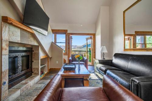 a living room with a leather couch and a fireplace at Mountain Lodge Telluride in Telluride