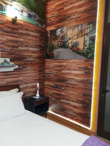 a bedroom with a wooden wall with a window at Albergue do Visconde in Touguinha