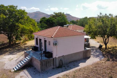 a small white house with a staircase leading to it at Chliara apartments by Tzalas in Skala Eresou