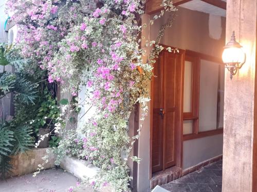 a building with flowers on the side of it at casa lumka hotel boutique spa in Mariquita