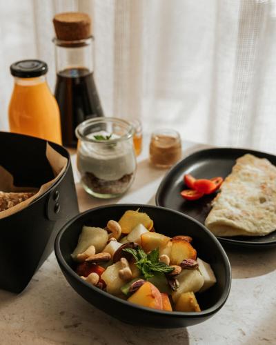 a table with a bowl of food and a plate of bread at AMÉNTE Mindful Stay in Plakias