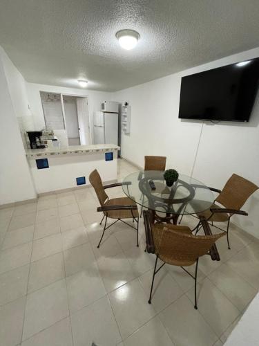 a dining room with a glass table and chairs at Departamento céntrico Huatulco in Santa Cruz Huatulco