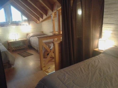 a bedroom with two beds and a desk and a window at Cabañas Orillas del Chimehuín in Junín de los Andes