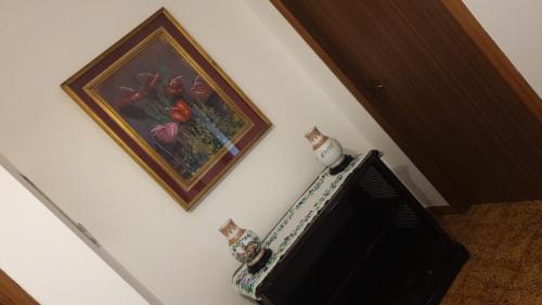 a picture of flowers on a wall next to a television at Dalla Fe' in Maglie