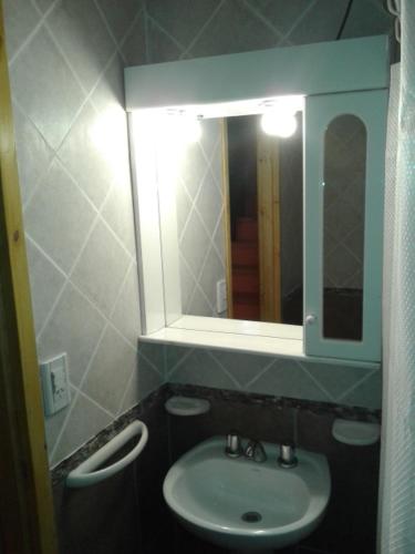 a bathroom with a sink and a mirror at Cabañas Orillas del Chimehuín in Junín de los Andes