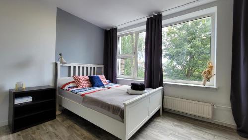 a bedroom with a bed and a large window at Apartamenty Parkowe nr 6 in Kwidzyn
