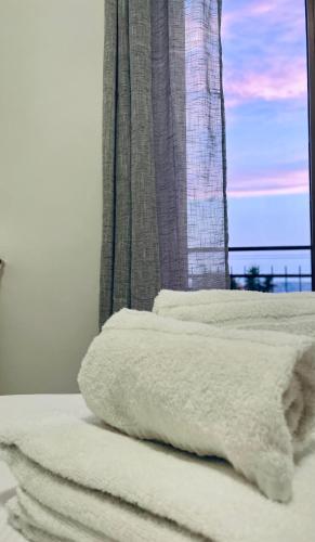 two white towels sitting on a bed with a window at Collina di Girgenti in Agrigento