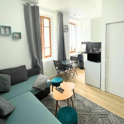 un salon avec un canapé bleu et une table dans l'établissement Charmant Appartement F2 - Paris 13ème, à Paris