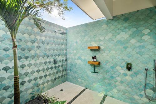a bathroom with a blue tiled shower with a palm tree at Casa Ola Aloha in Playa Avellana