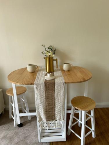 a wooden table with two stools and a table with a vase at Croft Courtyard, Ambleside in Ambleside