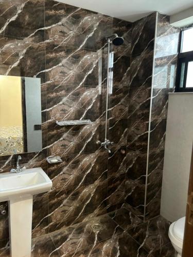 a bathroom with a shower and a sink at Eiffel appartment in Rāmkot