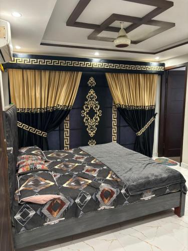 a bedroom with a bed in a room with curtains at Eiffel appartment in Rāmkot