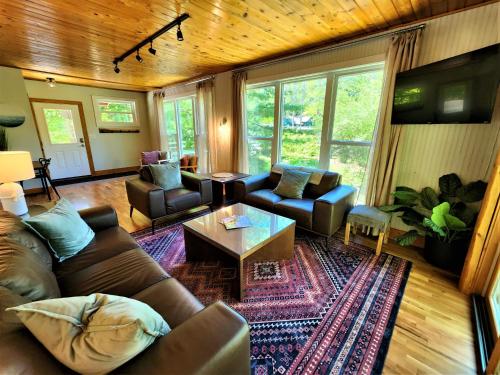 a living room with a couch and a table at Creekside Hot Tub-Walk to Beach-Uniquely Northern in Traverse City