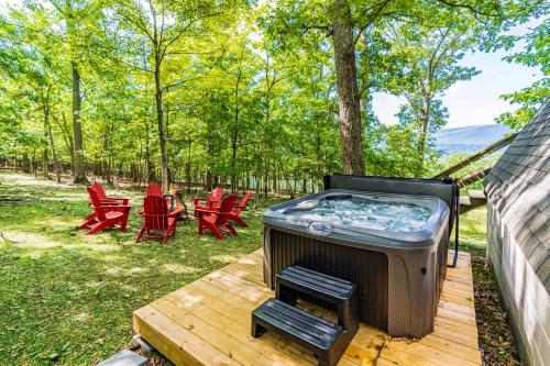 a hot tub on a deck with red chairs at Great Views! A-Frame w Hot Tub, Grill & Fire Pit in Morton Grove