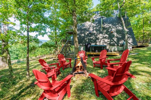 a group of red chairs sitting in the grass at Great Views! A-Frame w Hot Tub, Grill & Fire Pit in Morton Grove