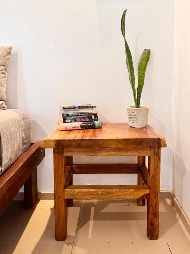 a table with a plant on it next to a bed at Chilamate Holiday House in Puerto Viejo