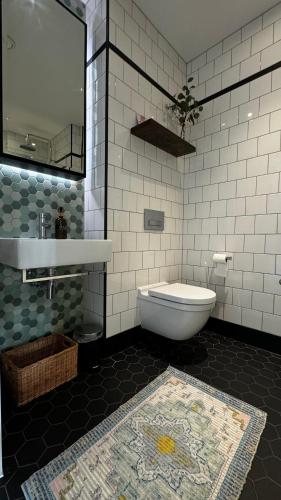 a bathroom with a tub and a toilet and a sink at London City Island 1 Bedroom Luxury Apartments, Private Balcony in London