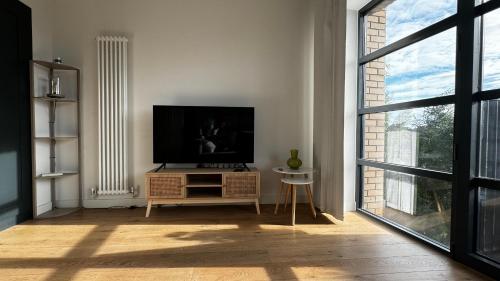 a living room with a flat screen tv on a white wall at London City Island 1 Bedroom Luxury Apartments, Private Balcony in London