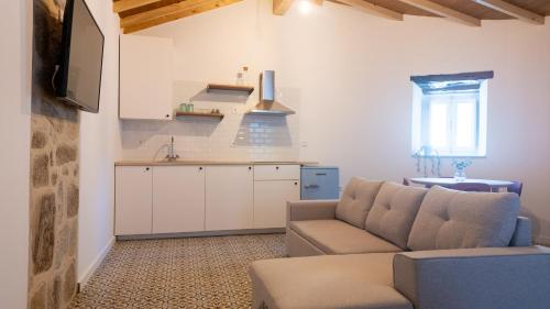a living room with a couch and a kitchen at Casa da Igreja by Casas do Planalto in Adeganha