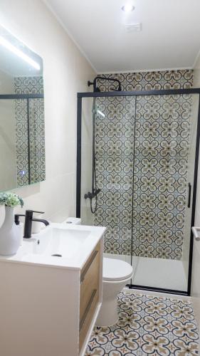 a bathroom with a sink and a toilet and a shower at Casa da Igreja by Casas do Planalto in Adeganha
