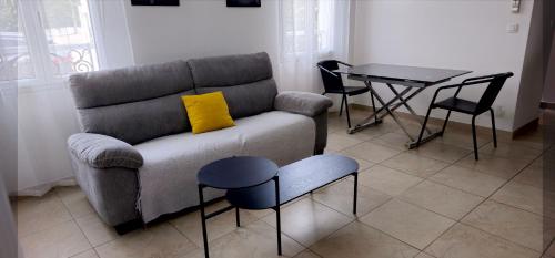 un salon avec un canapé et une table dans l'établissement Grand T2 Meublé-Juan Pins-Logt8, à Antibes