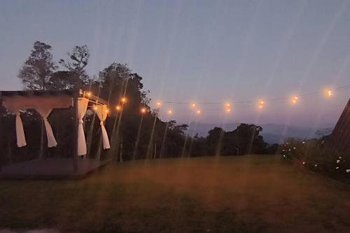 a foggy night with lights on a field at Chalé dos Encantos - Antônio Carlos in Antônio Carlos