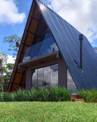 a house with a solar roof on top of it at Chalé dos Encantos - Antônio Carlos in Antônio Carlos