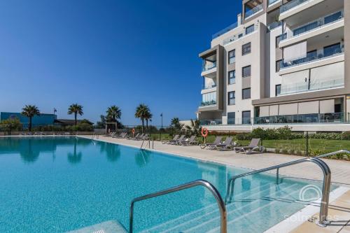 una gran piscina junto a un edificio alto en Los Flamencos EXCELLENT & SOLMARES, en Isla Canela