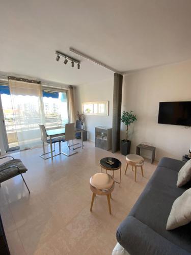 un salon avec un canapé et une table dans l'établissement 3 Pièces Vue mer & Iles de Lérins, à Cannes