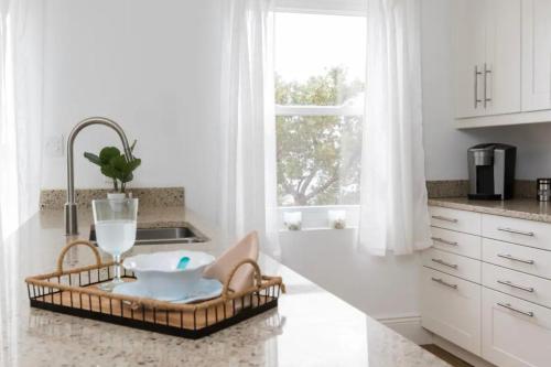 a kitchen counter with a sink and a bowl at Modern Apartment St Georges Bermuda in Saint George