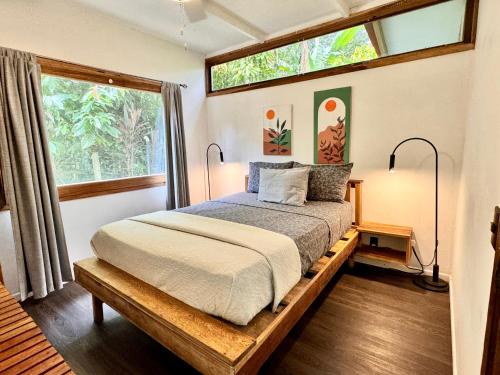a bedroom with a bed and a large window at Chilamate Holiday House in Puerto Viejo