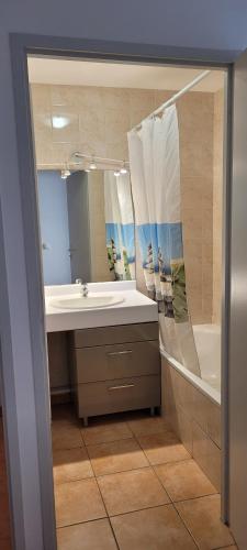 une salle de bain avec un lavabo, une baignoire et un miroir dans l'établissement Cosy 51m2 proche gare pour Genève et tram 3 min, à Annemasse