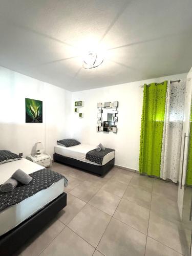 a bedroom with two beds and a green curtain at Villa Chiara in Limenaria