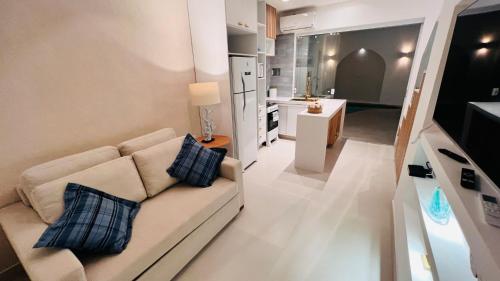 a living room with a couch and a kitchen at D'Blue Búzios Hotel Boutique in Búzios