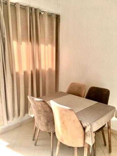 a dining room table with two chairs and a window at Mohammed V Airport Appartement in Deroua