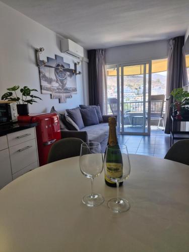 a bottle of wine and two glasses on a table at Torres del Sol 11th floor Atlantic view - Las Americas in Playa de las Americas