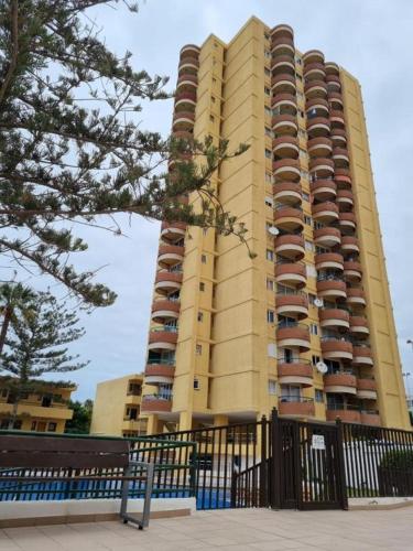 a tall yellow building with balconies in front of it at Torres del Sol 11th floor Atlantic view - Las Americas in Playa de las Americas