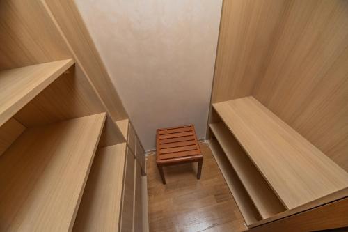 a small wooden stool in a room with wooden shelves at Villa Botanicus in Petrovac na Moru