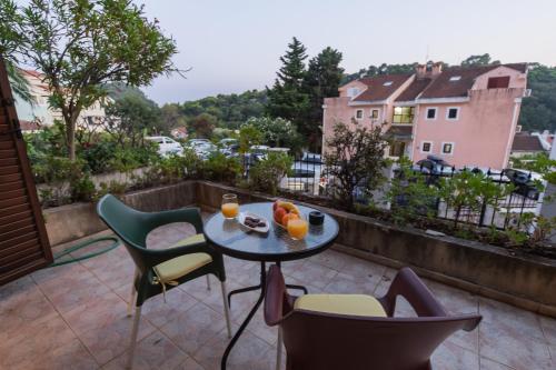 un patio con tavolo e sedie su un balcone di Villa Botanicus a Petrovac na Moru