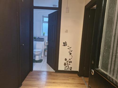 a bathroom with a toilet and a black door at Elegant & Spacious 2-Bedroom Apartment in Wimbledon in London