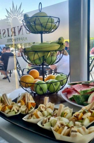 a table topped with plates of food and fruit at Sunrise Apart-Hotel in Ulcinj