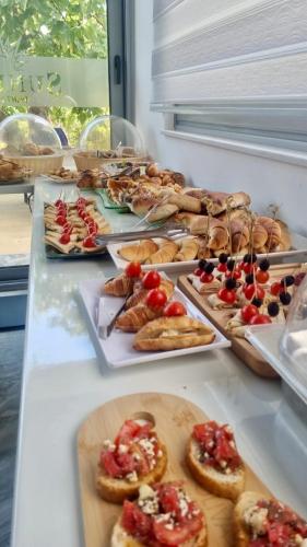 a buffet filled with different types of food on trays at Sunrise Apart-Hotel in Ulcinj