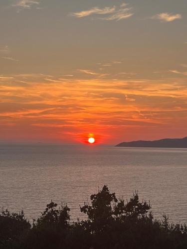 a sunset over the water with the sun in the sky at Vila Natalia in Petrovac na Moru