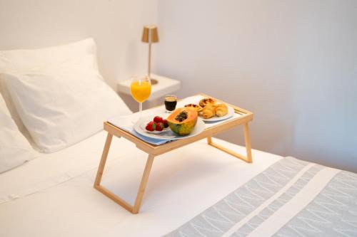 een dienblad met eten op een tafel op een bed bij Seaside Cozy Apartment with private Terrace in Porto