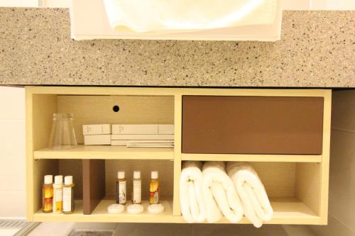 a cupboard with towels and products in a kitchen at Hotel Migliore Seoul in Seoul