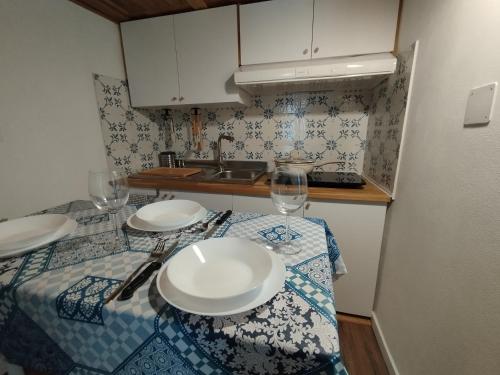 Una cocina con una mesa con platos y copas de vino. en La casa di nonno Nicola, en San Vito Chietino
