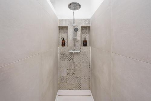 a bathroom with a shower with two bottles at L'Escapade de Pierrefonds - vue château - jardin in Pierrefonds