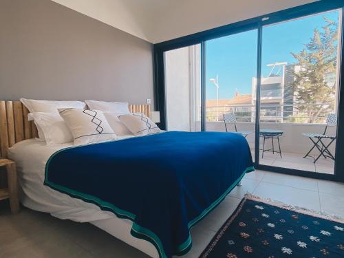 une chambre avec un lit et une grande fenêtre dans l'établissement Villa avec piscine à Carnon Plage à 20m de la plage idéale pour 8 à 10 personnes, à Mauguio